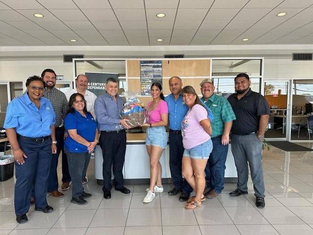 Group photo during gift basket presentation at Chevrolet showroom