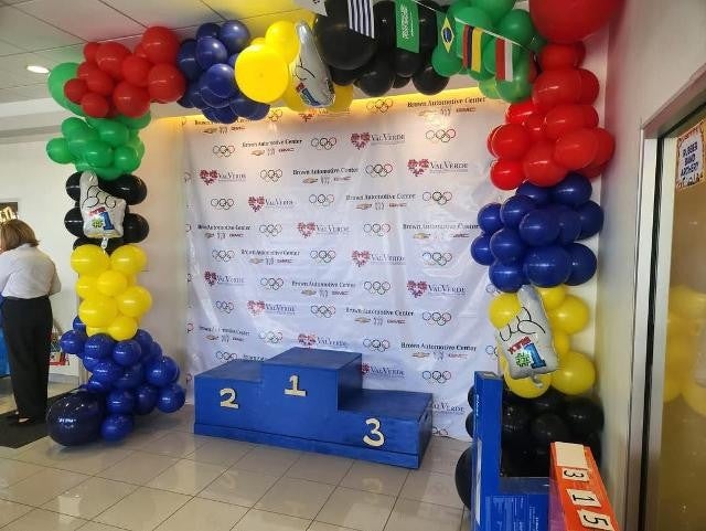 Olympic-themed balloon setup with winner podium at event backdrop