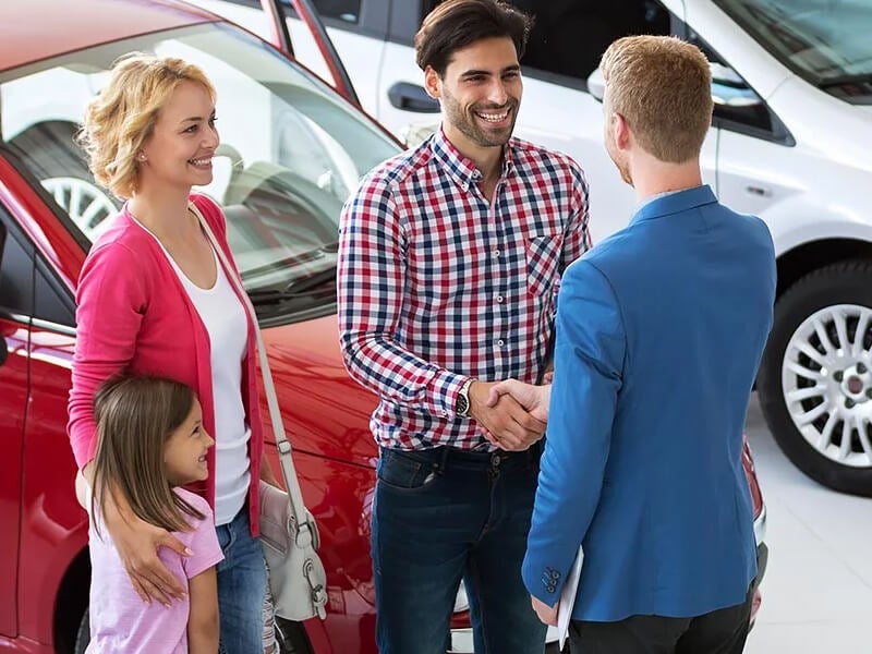 Salesman assisting a happy Family